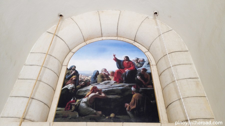 A painting depicting Jesus preaching His disciples is displaced above the main entrance door of the Church of Mt Beatitudes
